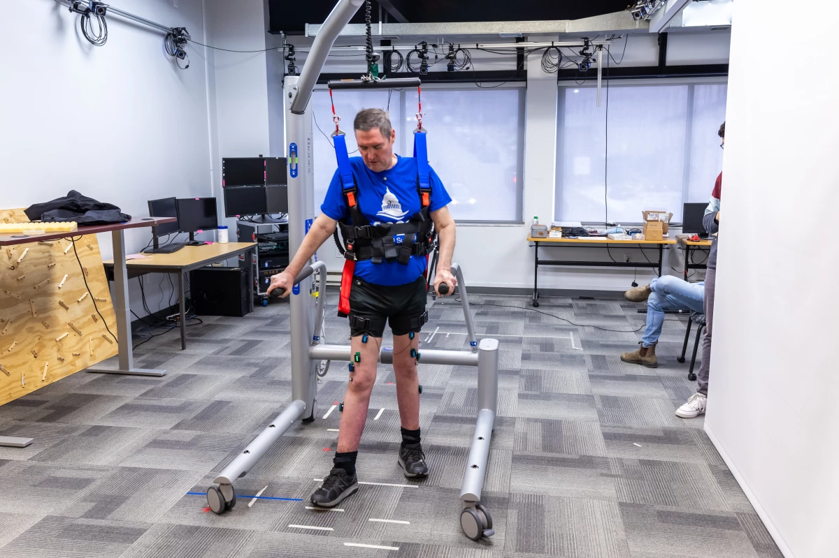 Research participant Doug McCullough uses the bodyweight support system to walk during a testing session at the University of Pittsburgh.