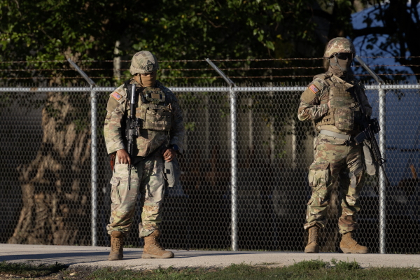 Members of the Texas National Guard stand guard at an army reserve training facility on October 07, 2025 in Elwood, Illinois.