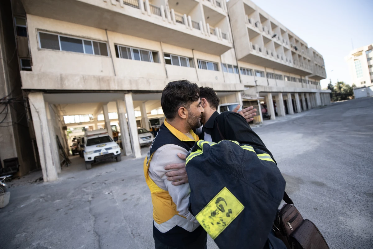 Mustafa Bakkar (left), operations chief for the White Helmets, hugs firefighter Mohammed Khdeir.