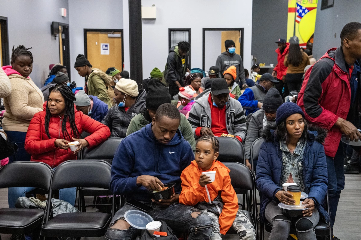 Migrants eat a meal at the La Colaborativa day shelter in Chelsea, Massachusetts, on February 22, 2024. The shelter opened on February 20, and helps migrants, mainly from Haiti, build resumes, get work, receive health care.