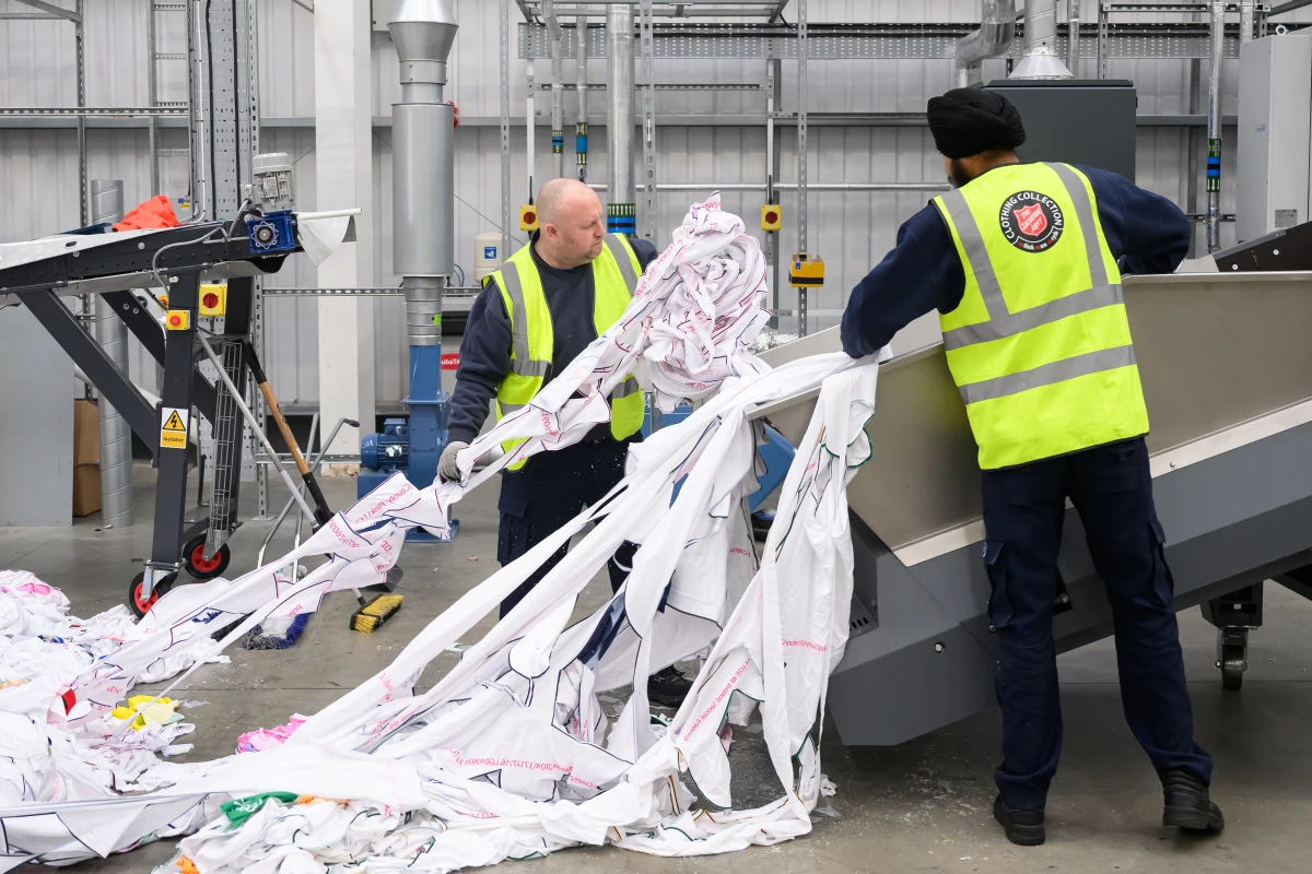 Workers load unwanted polyester textiles into the Project Re:Claim system, the first commercial-scale polyester recycling plant of its kind, on February 28, 2025 in Kettering, England.