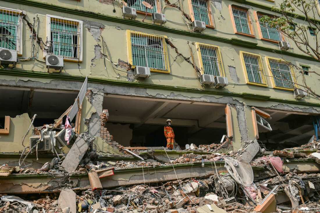 A rescue worker looks out over the rubble