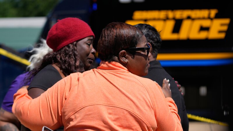 People console each other as they gather at the scene of a mass shooting in ShreveportLa.on Sunday.