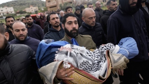 A Palestinian man carries Muhammad Bani Odeh, 5, at the funeral of four members of the Odeh family who were killed in their car by Israeli security forces during an army operation in Tammun, West Bank, Sunday, March 15, 2026. 