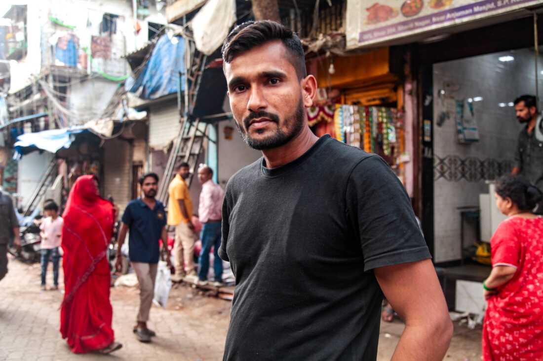 Mohammad Saiyub poses for an image in a crowded Mumbai quarter on a recent February day. Saiyub appeared in an image that went viral during the early days of the pandemic. He, a Muslim, tried to save the life of his best friend, Amrit Kumar, a Dalit Hindu, in the early days of the pandemic. The two were hitching a ride home, a journey of nearly a 1,000 miles, when Kumar fell ill and was kicked off the truck they were on. Saiyub stayed with his friend by the roadside, waiting for assistance. The backstory of that viral image was told in a 2020 New York Times essay, which went on to inspire the movie.