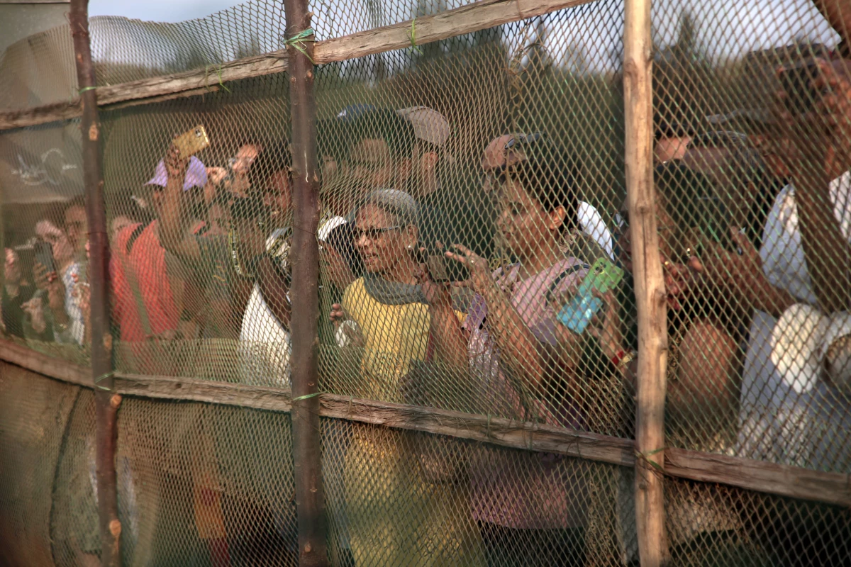 Tourists gather around a netted hatchery on the seashore at the western Indian village of Velas, where olive ridley turtles come to nest.