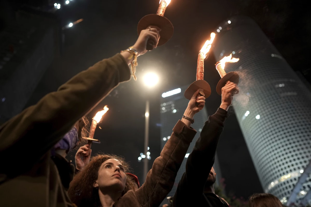 Demonstrators hold torches as they gather during a protest calling for the release of all hostages held captive by Hamas in the Gaza Strip, in Tel Aviv, Israel on Saturday, Jan. 18, 2025.