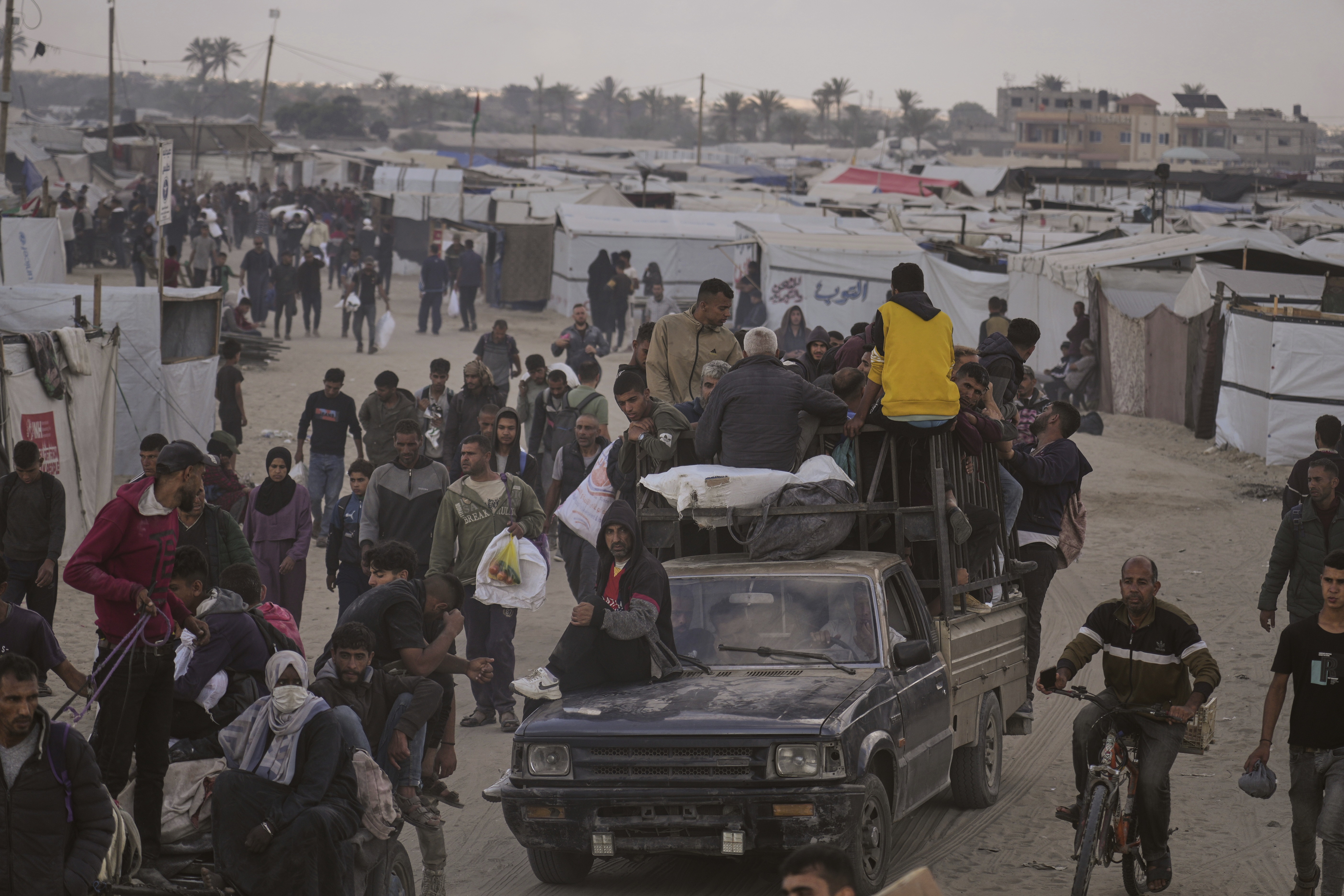 Palestinians carry bags filled with food and humanitarian aid provided by the Gaza Humanitarian Foundation, a U.S.-backed organization approved by Israel, in Khan Younis, southern Gaza Strip, on Tuesday, June 3. (AP)