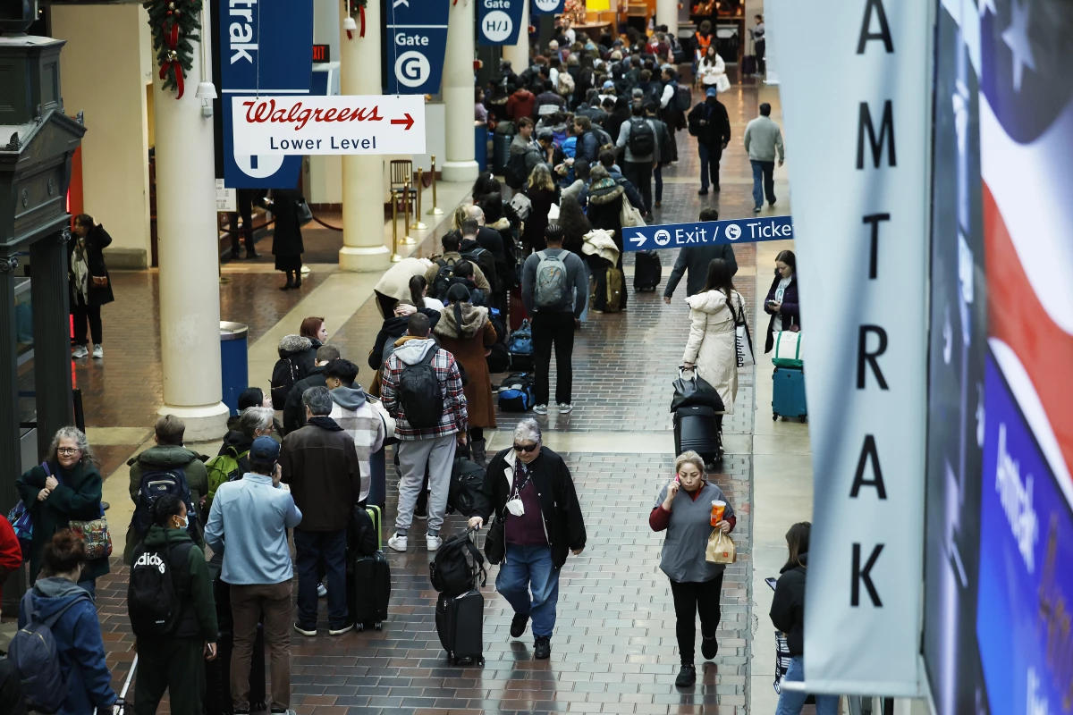 Travelers wait in line to board an Amtrak Northeast Regional train at Union Station in December 2023.