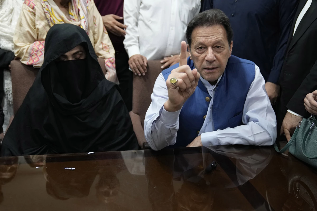 Pakistan's former Prime Minister Imran Khan, right, with his wife Bushra Bibi, speaks to the media before signing documents to submit surety bond over his bails in different cases, at an office of Lahore High Court in Lahore, Pakistan, on July 17, 2023.