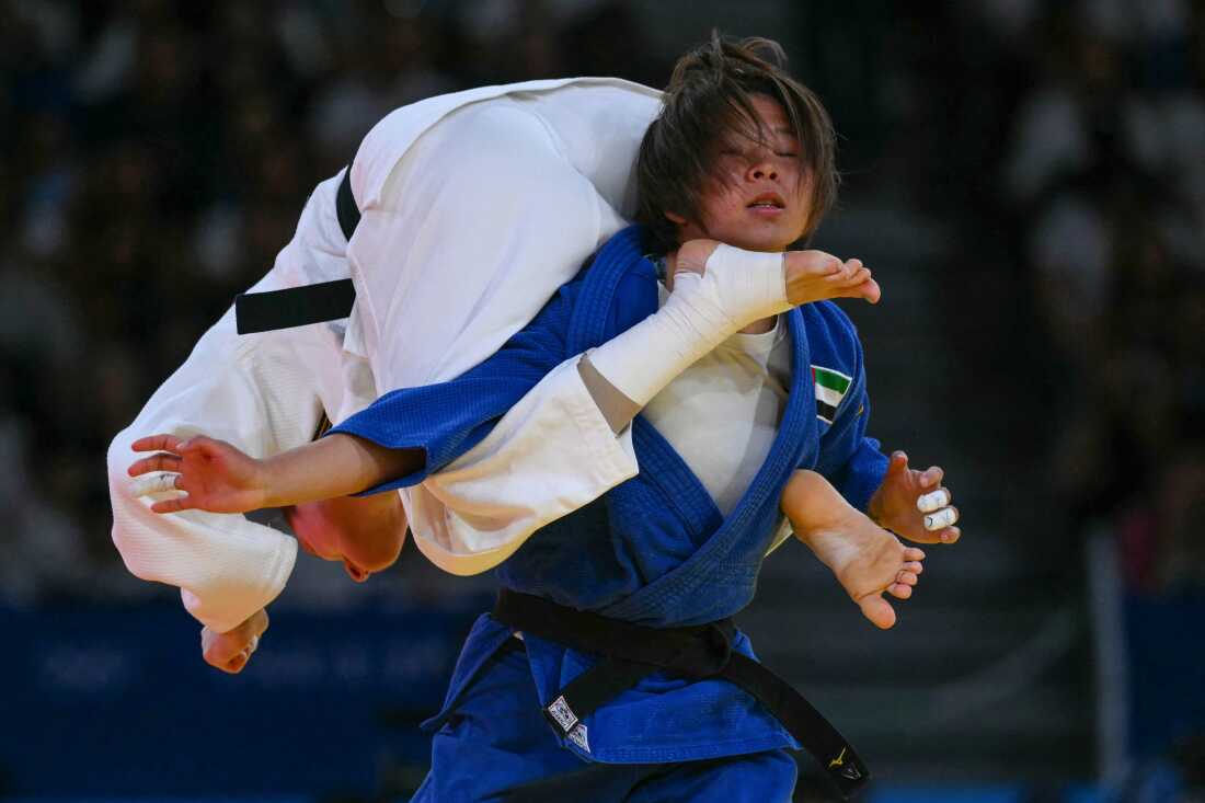 Germany's Mascha Ballhaus and United Arab Emirates' Khorloodoi Bishrelt (blue) compete in the judo women's -52kg round of 16 bout of the Paris 2024 Olympic Games at the Champ-de-Mars Arena, in Paris on July 28, 2024. (Photo by Luis ROBAYO / AFP) (Photo by LUIS ROBAYO/AFP via Getty Images)