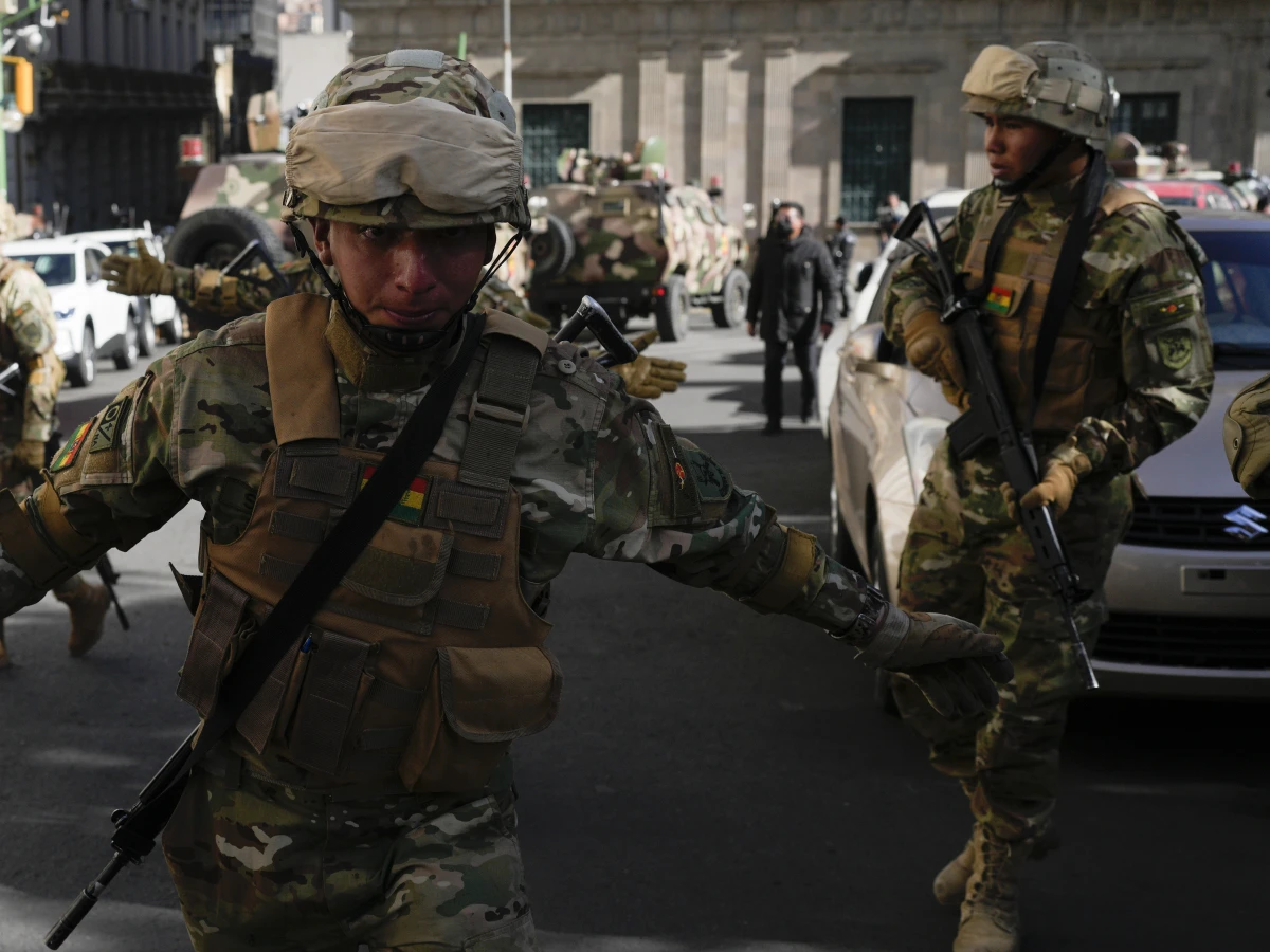 A soldier gestures for journalists to leave Plaza Murillo as soldiers gather outside the presidential palace in Plaza Murillo in La Paz, Bolivia, on Wednesday. Bolivian President Luis Arce warned that an “irregular” deployment of troops was taking place in the capital, raising concerns that a potential coup was underway.