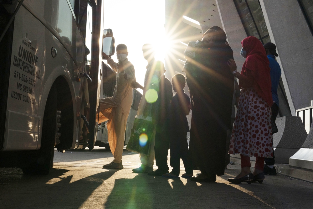 Families evacuated from Kabul, Afghanistan, wait to board a bus after they arrived at Washington Dulles International Airport, in Chantilly, Va., on Aug. 27, 2021. (AP)