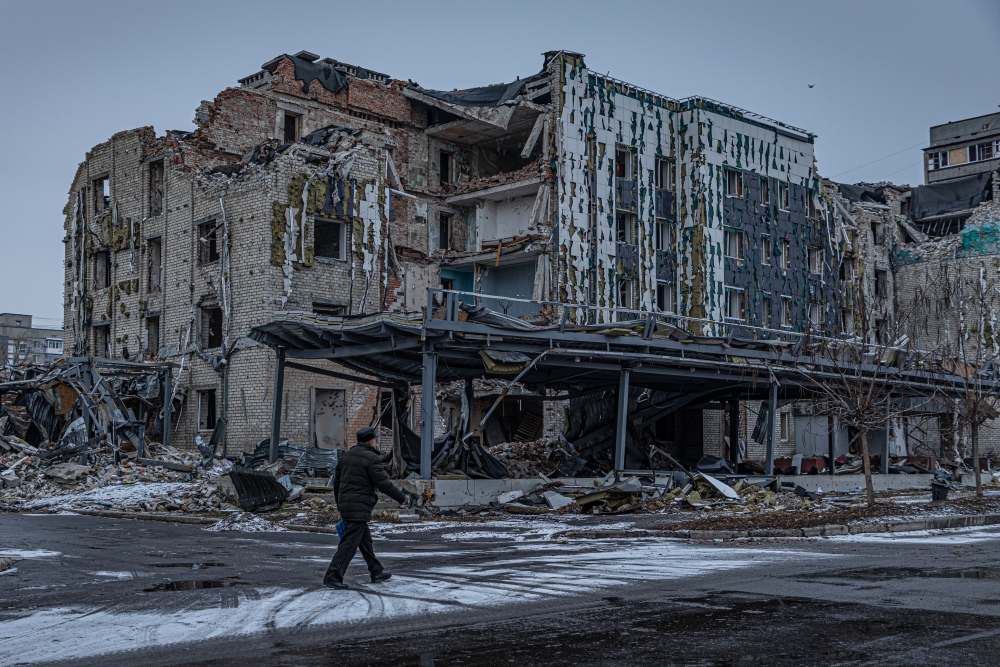 A man walks down a war-ravaged street in Pokrovsk, an industrial city in eastern Ukraine's Donetsk region, on Dec. 19, 2024. Behind him is the hotel Druzhba, which was destroyed by a Russian missile last summer. Pokrovsk was once home to 60,000 people. Now it's largely abandoned, with Russian troops active within a mile of the outskirts.
