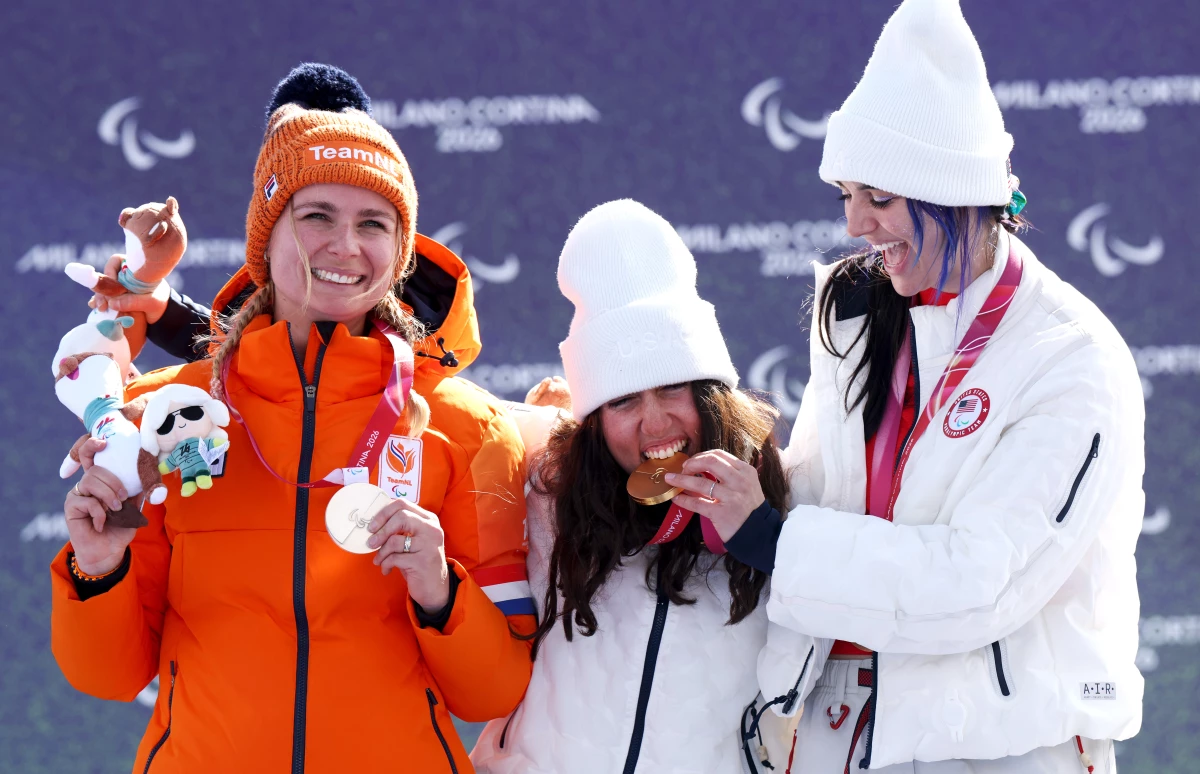 Kate Delson, center, and Brenna Huckaby, right, of Team U.S. pose for a photo on the podium during the medal ceremony for the para snowboard banked slalom.