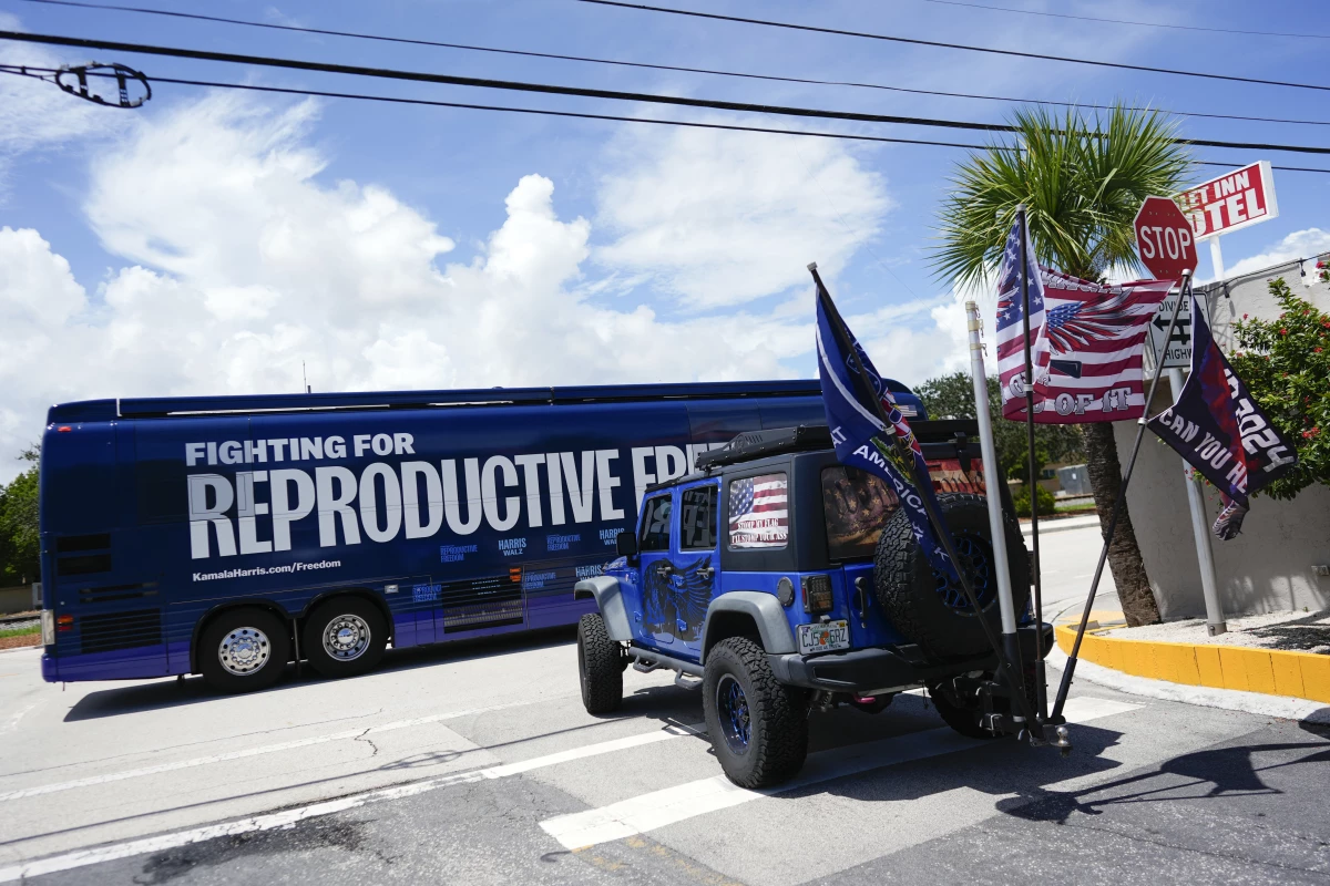 Supporters of Republican presidential nominee former President Donald Trump, who turned out to protest against abortion wait to follow the bus at the start of the 'Reproductive Freedom Bus Tour' by the campaign of Democratic presidential nominee Vice President Kamala Harris and running mate Gov. Tim Walz, Tuesday, Sept. 3, 2024, in Boynton Beach, Fla.