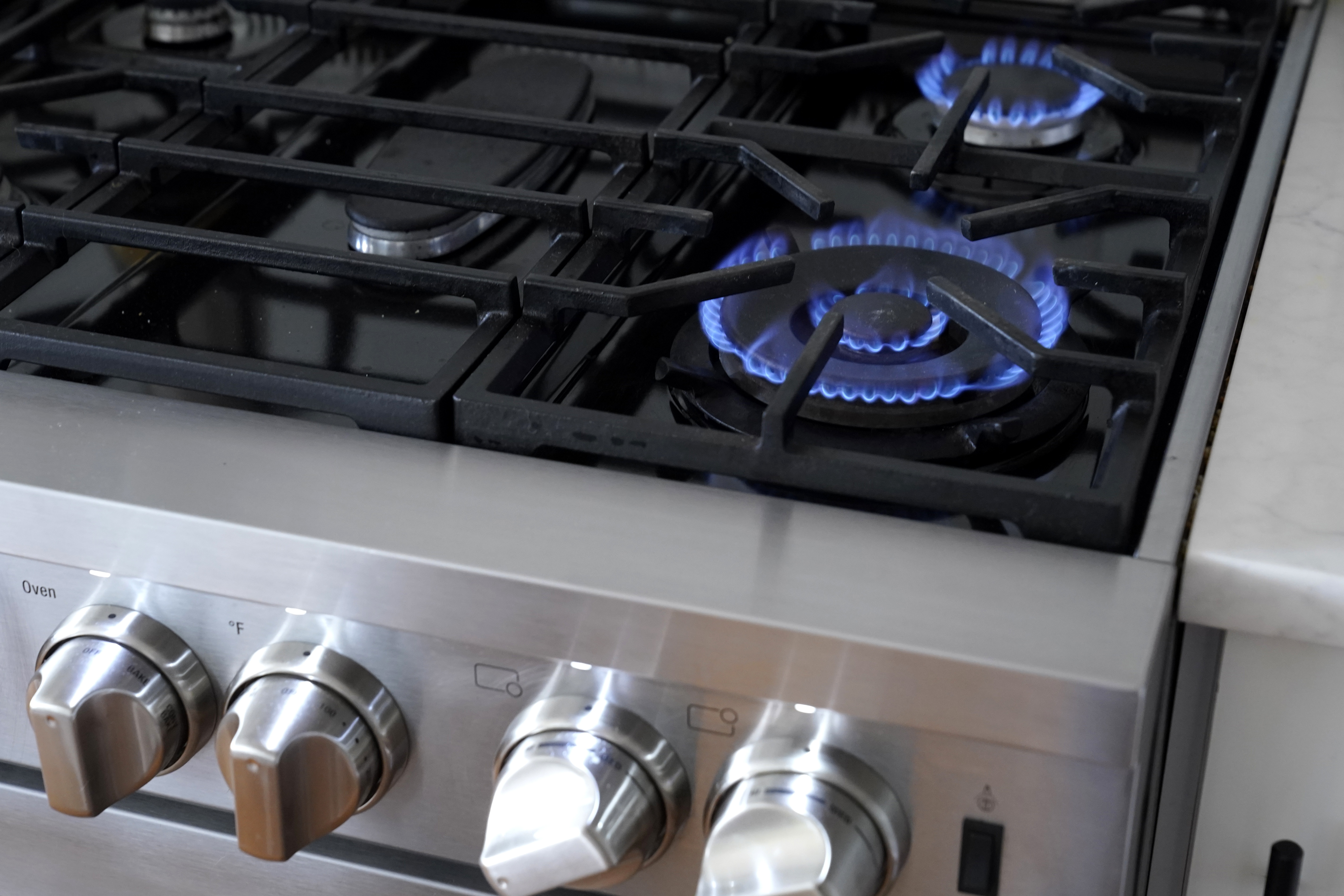 The blue flames of a natural gas stove emit harmful pollutants, such as nitrogen dioxide. Consumer and environmental watchdog groups want health warning labels on new gas stoves to let buyers know of the risks. (AP)