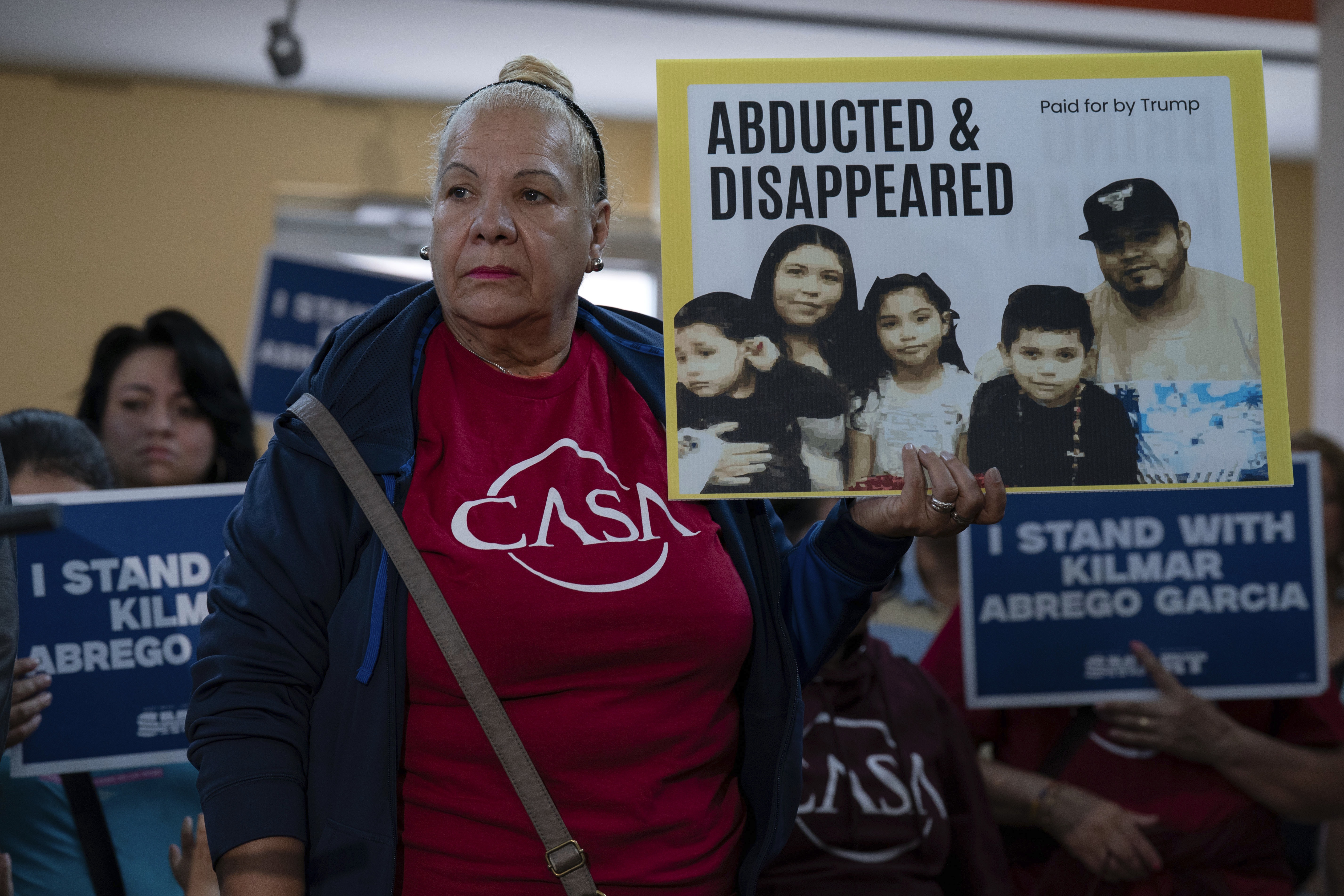 Supporters hold up signs as Jennifer Vasquez Sura, the wife of Kilmar Abrego Garcia of Maryland, who was mistakenly deported to El Salvador, speaks during a news conference at CASA