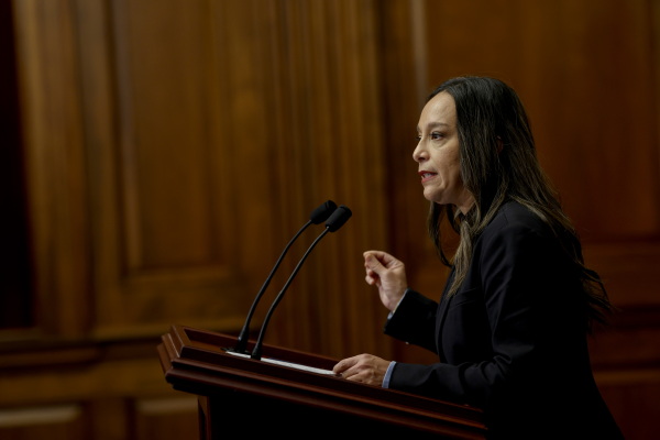 Rep. Monica De La Cruz, R-Texas, speaks to reporters during a news conference at the U.S. Capitol in 2023. Wearing a dark blazer, she's standing at a lectern that has two microphones attached to it. Wood-paneled walls appear in the background.