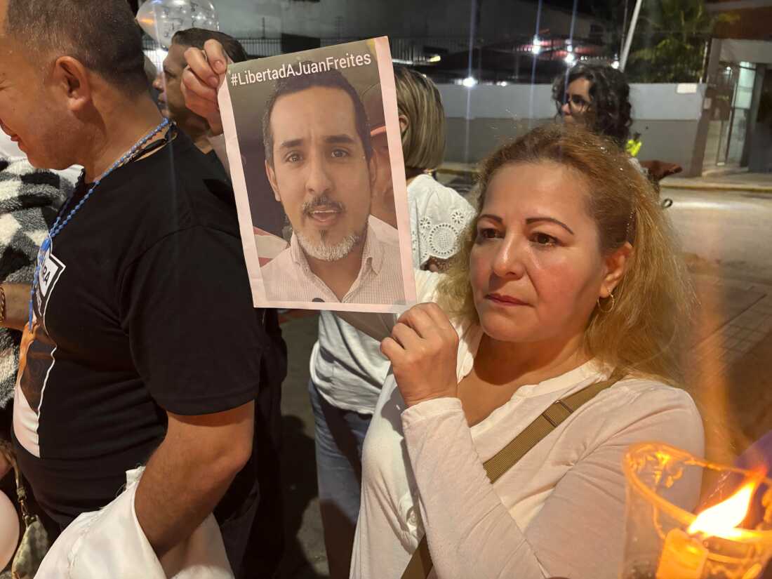 Atali Freites, holds a photo of her son Juan Freites, during a vigil outside the Helicoide Prison in Caracas. Freites, an opposition activist has been in prison for more than two years.