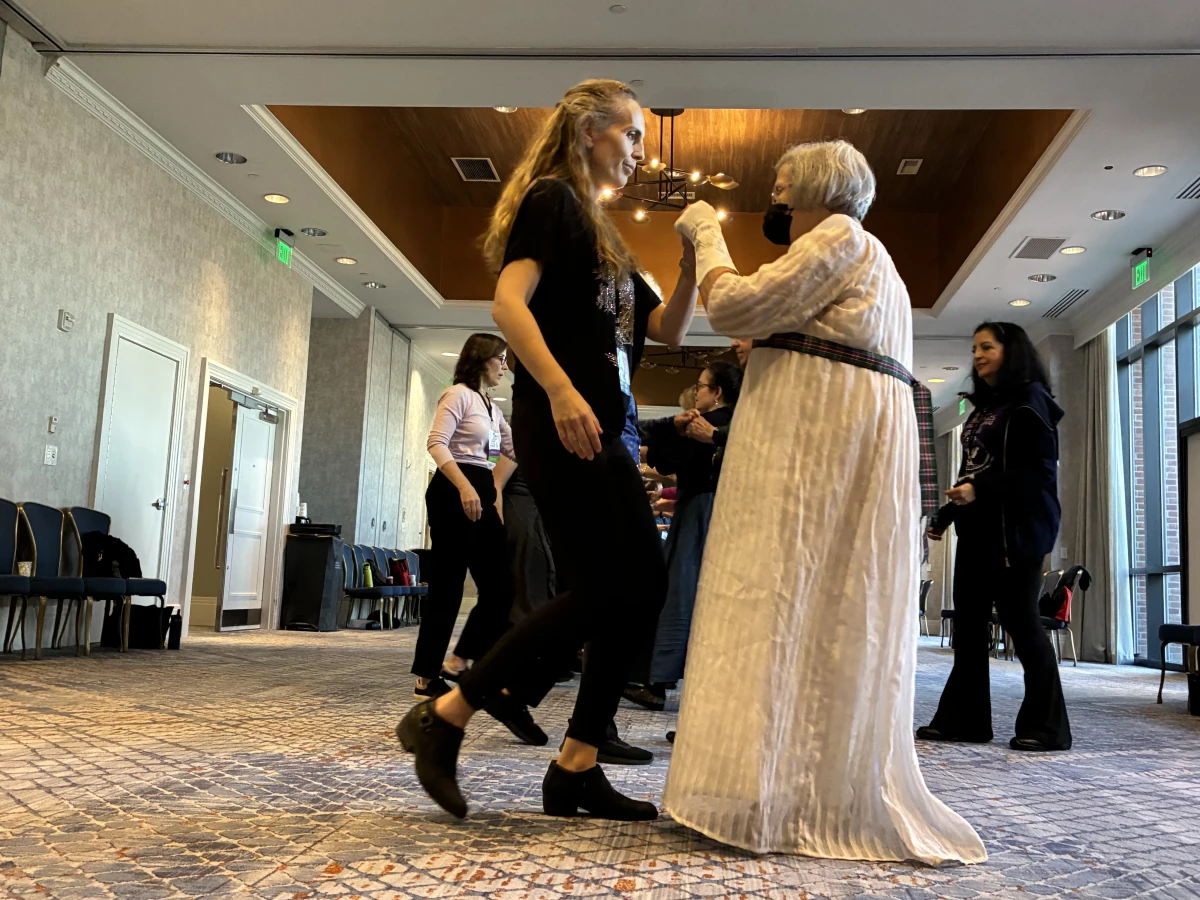 Tessa Harings (left) learns English country dance at the Jane Austen Society of North America's 2025 Annual General Meeting