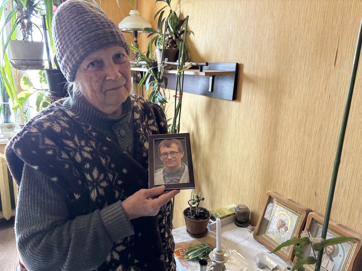 Olga Ivanivna, 78, holds a picture of her son, a doctor, who died five years ago.