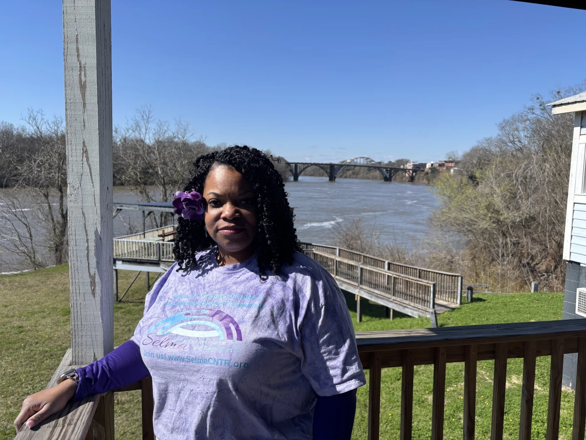 Standing by the Alabama River with the Edmund Pettus Bridge behind, Ainka Sanders Jackson, a former public defender, reflects on change, 'we have seen progress, but progress is slow.'