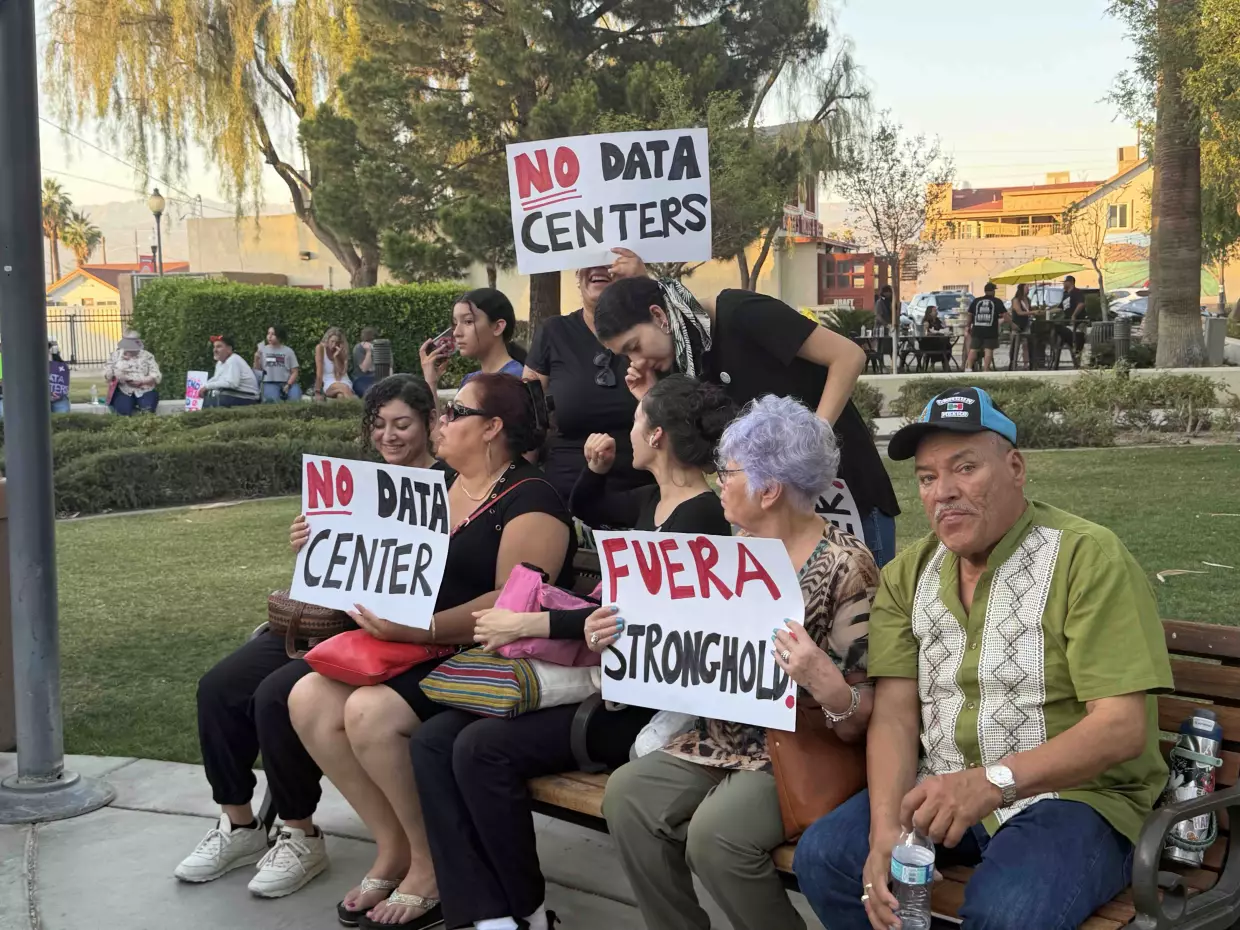 Maria Duarte, center right holding a "Fuera Stronghold" sign, said she has lived in the Coachella Valley since the 1970s and worries data centers could bring more costs than benefits for local residents.