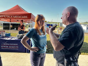 Lindsay James speaks to Kip Ladage, an Iowan concerned about health care, at the Bremer County Fair in Waverly.