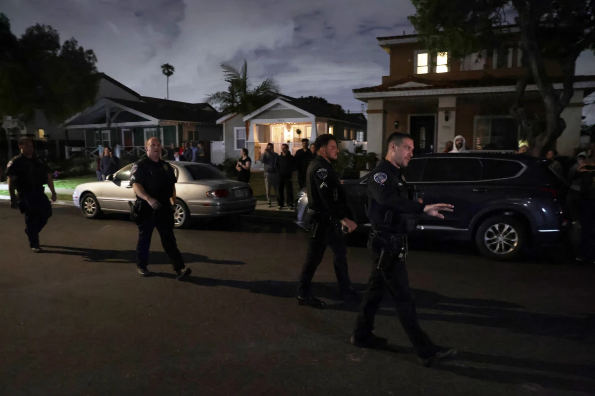 Law enforcement officials respond to an address connected to Cole Tomas Allen, the shooting suspect at the White House Correspondents' Dinner, as people stand and watch on Saturday in Torrance, Calif.