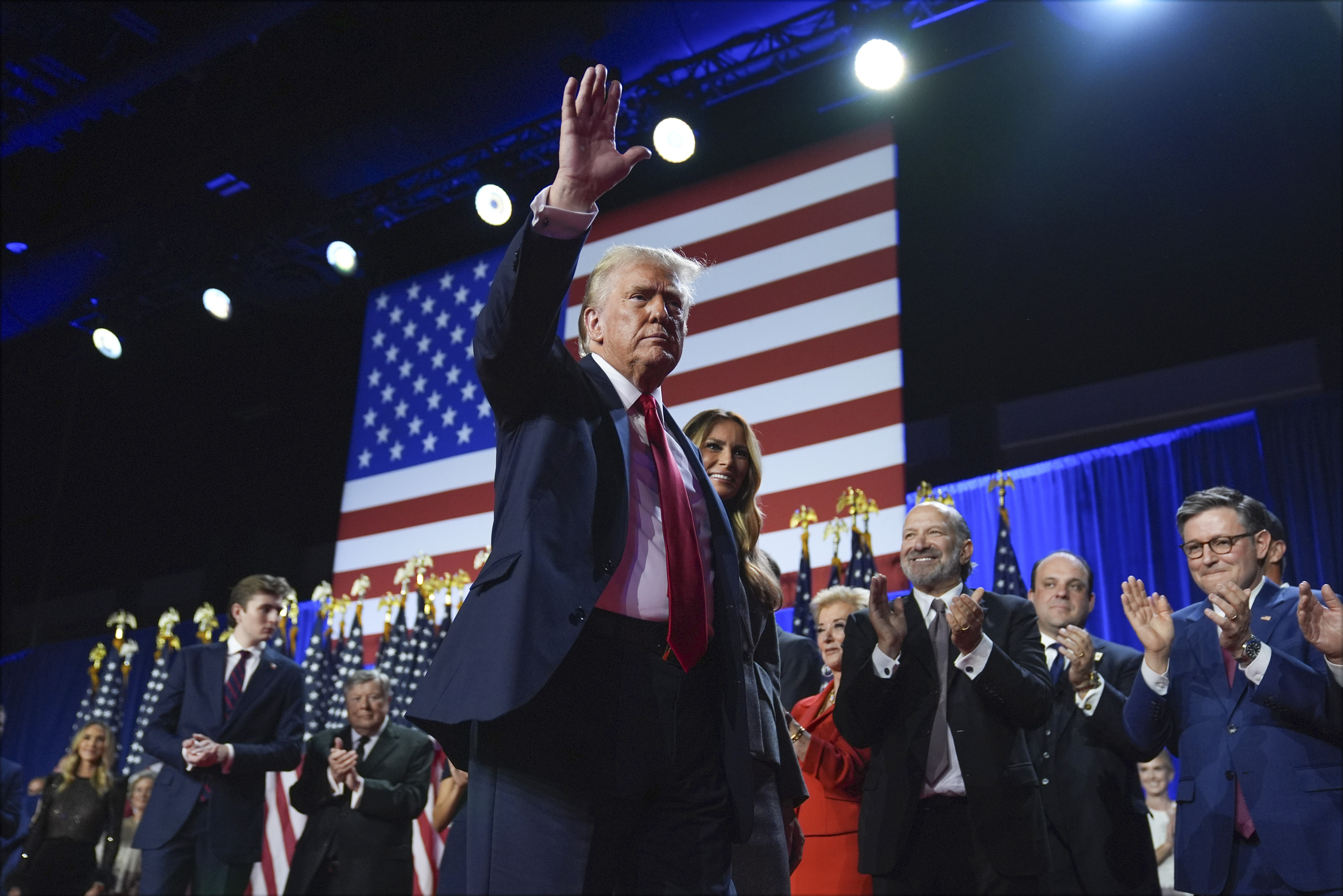 Former President Donald Trump waves as he walks with Melania Trump at an election night watch party at the Palm Beach Convention Center in West Palm Beach, Fla. (AP)