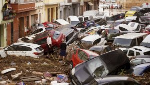 Residents look at cars piled up after being swept away by floods in Valencia, Spain, Wednesday.
