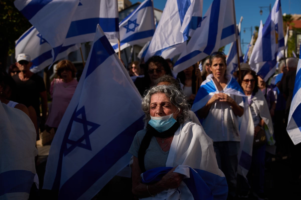 Mourners walk near the car carrying the coffin of slain hostage Guy Illouz during his funeral procession in Rishon Lezion, Israel, on Wednesday. Illouz's remains were returned from Gaza to Israel as part of a ceasefire agreement between Israel and Hamas.