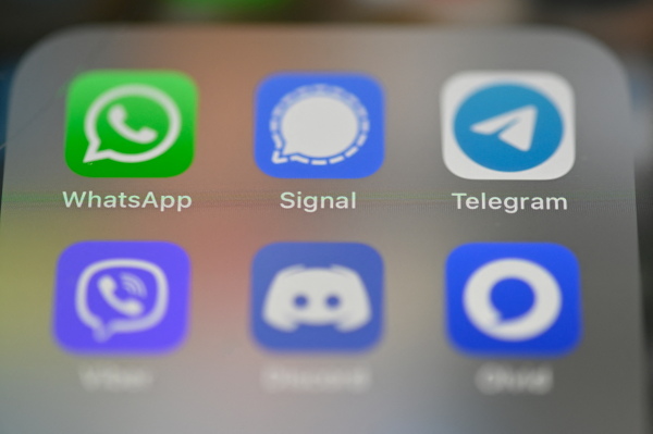 A smartphone's screen shows messaging apps including WhatsApp, Signal and Telegram.