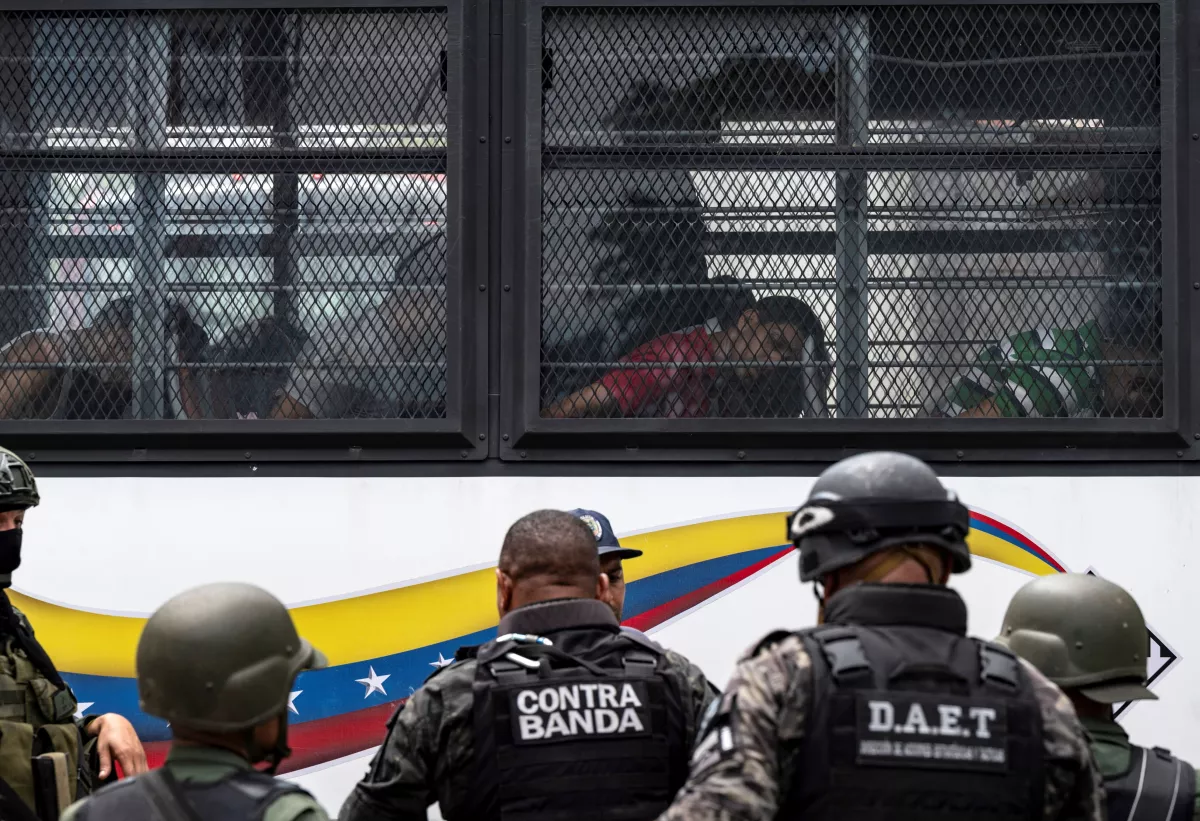 Members of the Bolivarian National Guard (GNB) stand guard as inmates aboard a bus are transferred outside the Tocoron prison in Tocoron, Aragua State, Venezuela, on September 20, 2023.