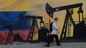 A pedestrian walks past a mural featuring oil wells in Caracas, Venezuela, Saturday, Aug 29, 2026, a day after President Donald Trump announced a deal giving the United States a stake in Venezuela’s oil reserves. (AP Photo/Pedro Mattey)
