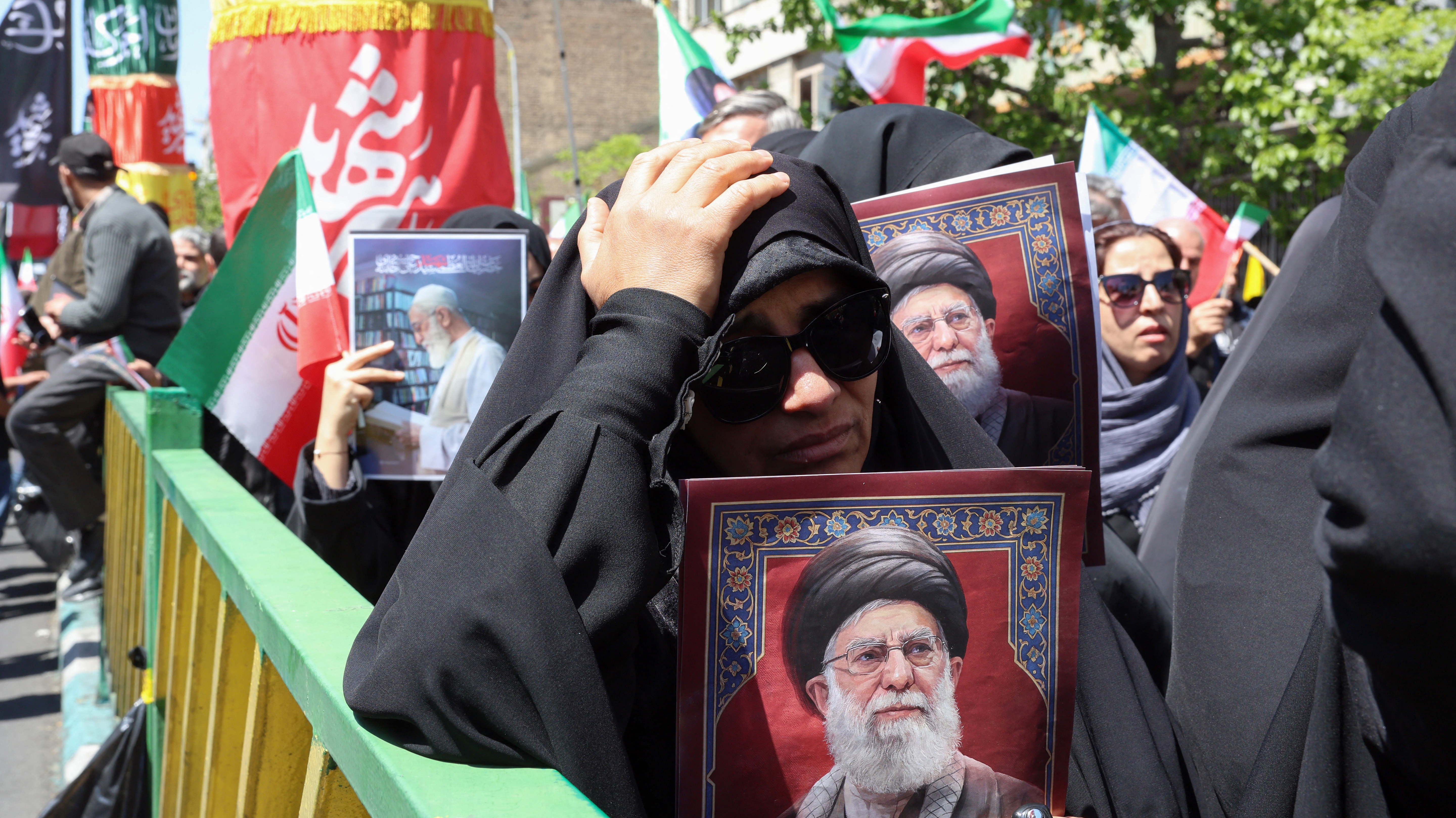 Iranians hold portraits of slain Iran