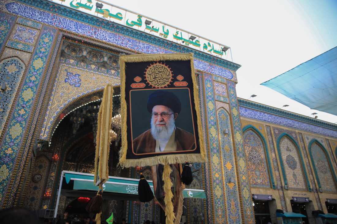 Pilgrim carries a portrait of Iran's Supreme Leader, Ali Khamenei, outside the Imam Hussein Shrine in Karbala during the Arbaeen pilgrimage.