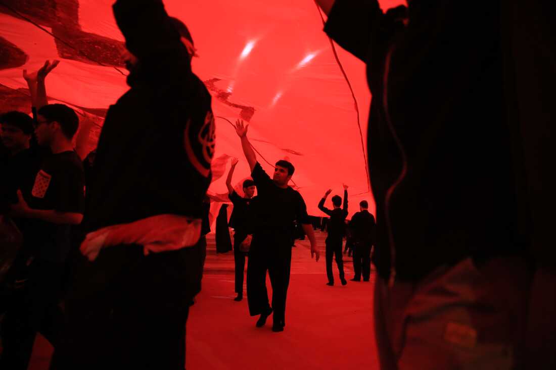 Pilgrims hold a large piece of fabric above their heads while taking part in mourning rituals inside the Imam Hussein Shrine in Karbala during the Arbaeen commemoration.