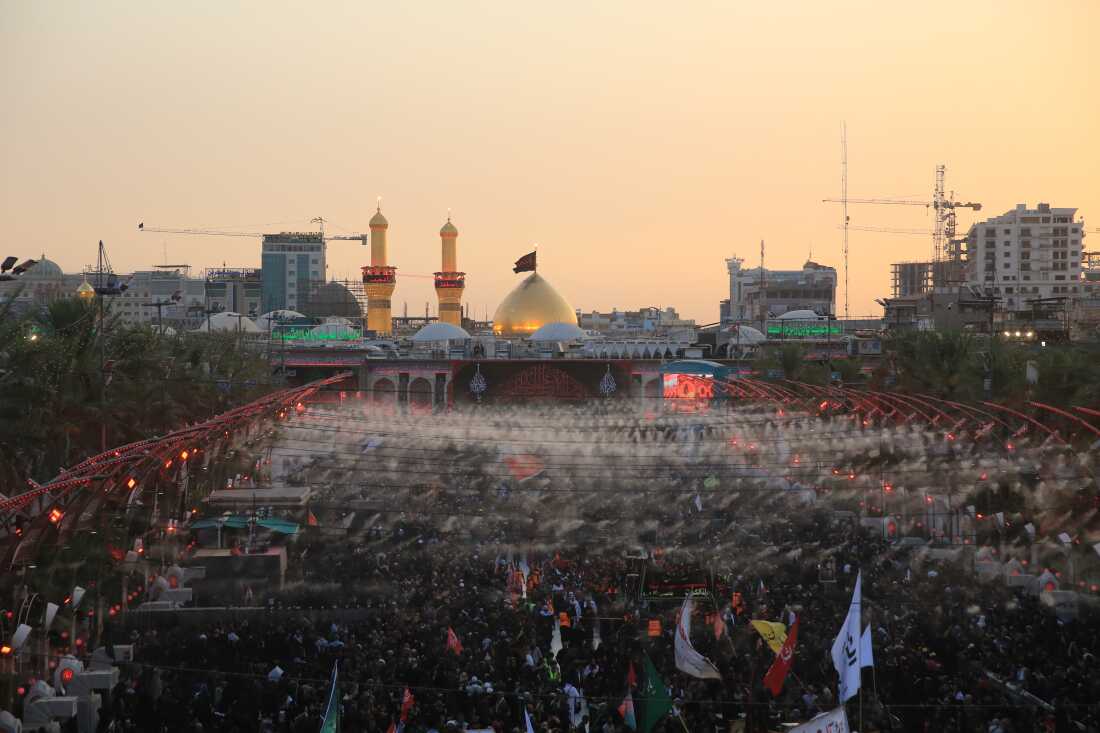 Large crowds of pilgrims fill the area between the two holy shrines in Karbala at sunset