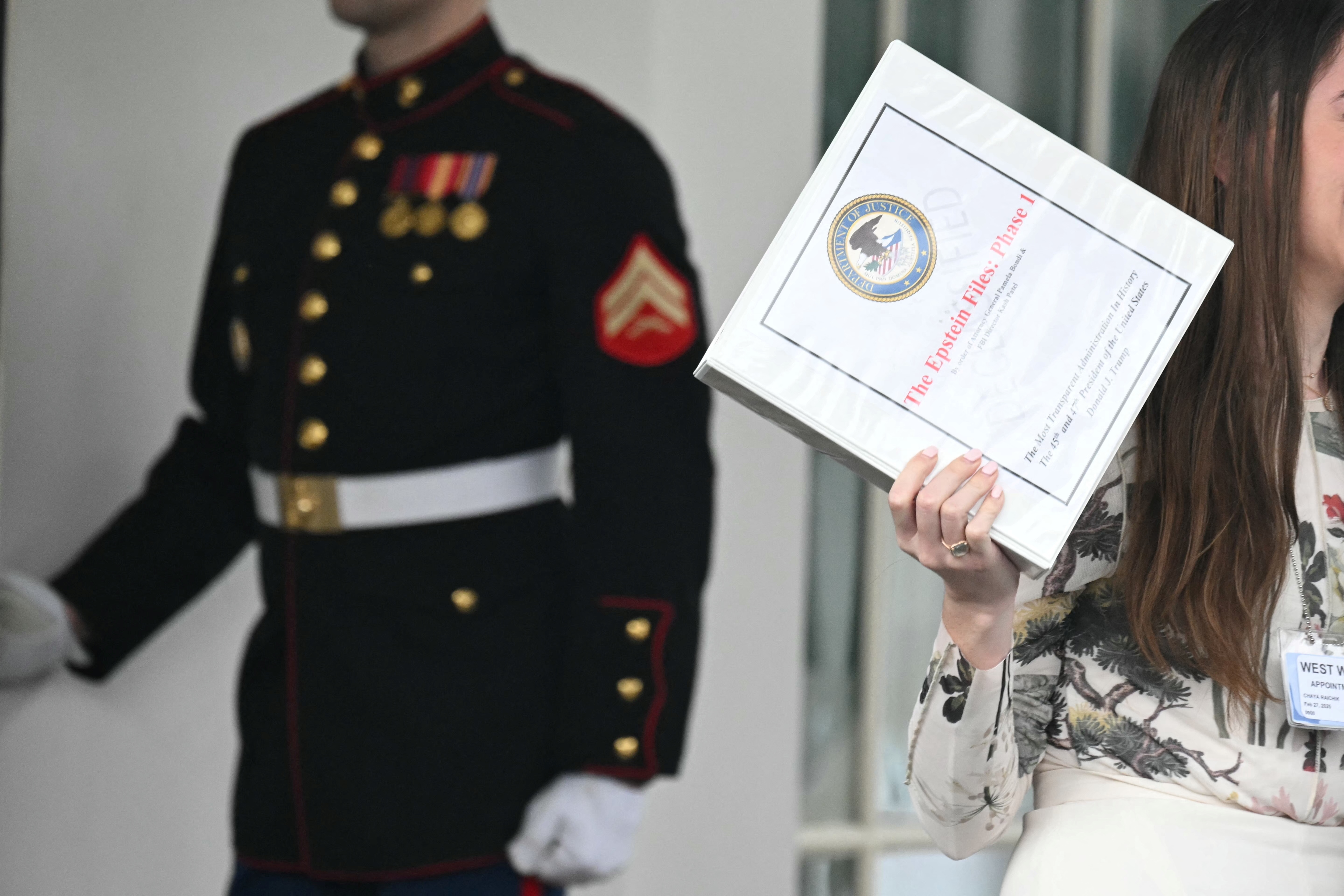 Unidentified people carrying binders bearing the seal of the US Justice Department reading "The Epstein Files: Phase 1" walk out of the West Wing of the White House in February. The Trump administration had promised it would release documents on late tycoon and convicted sex trafficker Jeffrey Epstein who was found dead in his prison cell in 2019.