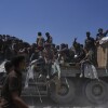 Palestinians hold onto an aid truck returning to Gaza City from the northern Gaza Strip, Sunday.