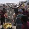 Palestinians struggle to get donated food at a community kitchen in Khan Younis, Gaza Strip on Friday, May 16.