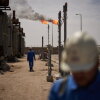 Workers walk in the Zubair oil field, whose operations have being reduced since the start of the Iran war, near Basra, Iraq, March 28.