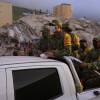 Venezuelan firefighters and volunteers search for possible victims atop a collapsed building in Caraballeda, La Guaira state, Venezuela, on June 27.