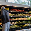 A man gathers produce from shelves of vegetables in an H-E-B grocery store in Austin, Texas, on May 11.