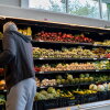 A man gathers produce from shelves of vegetables in an H-E-B grocery store in Austin, Texas, on May 11.
