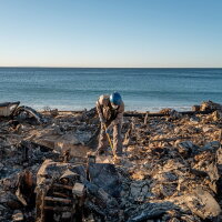Patrick O'Neal sifts through his home on Monday after it was destroyed by the Palisades Fire in Malibu, Calif. Multiple wildfires fueled by intense Santa Ana winds are burning across Los Angeles County.