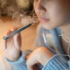 Uma jovem vaporiza um cigarro eletrônico.