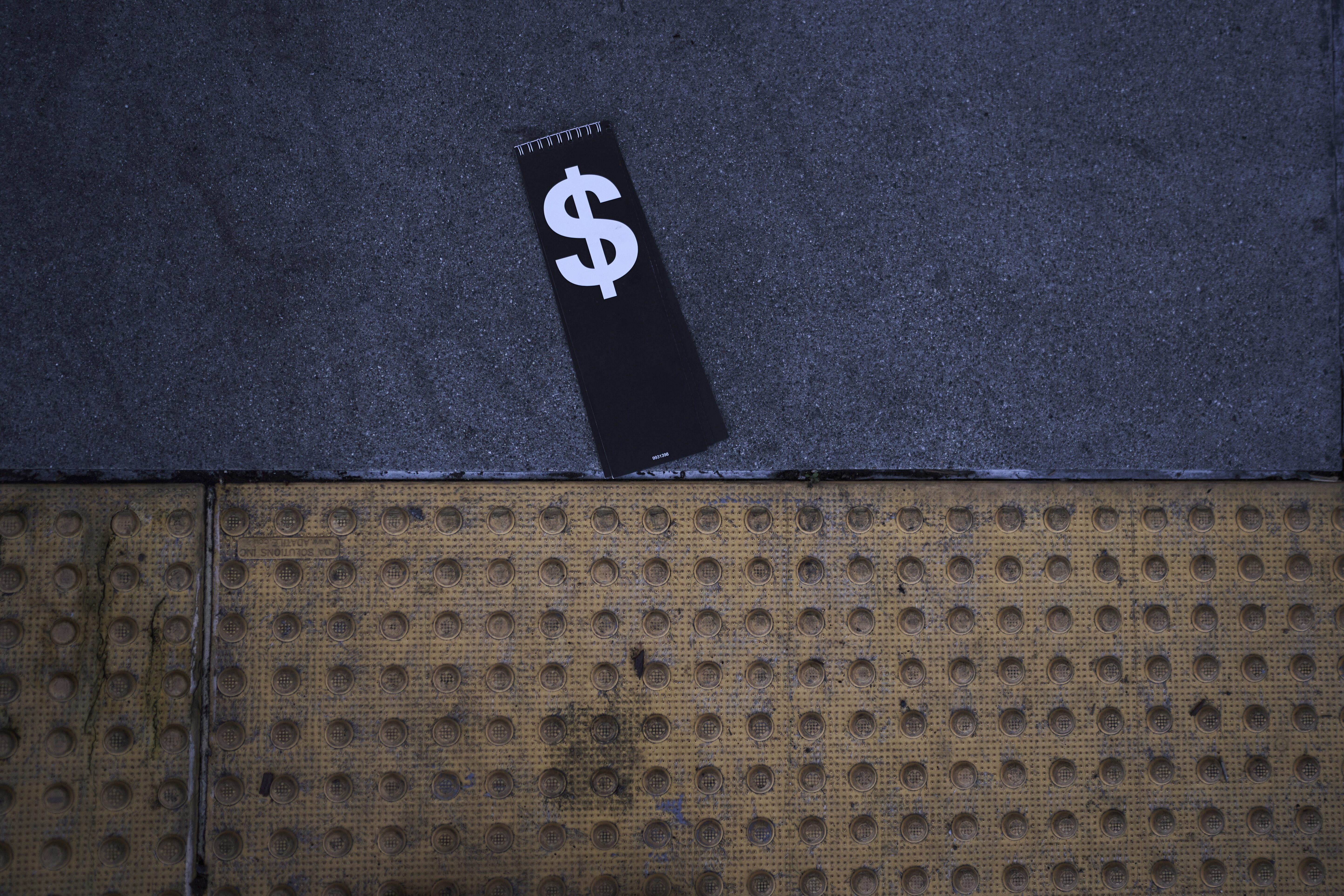 A price tag with a dollar sign lies on the sidewalk outside a Walmart store in La Habra, Calif., Wednesday, April 2. (AP)